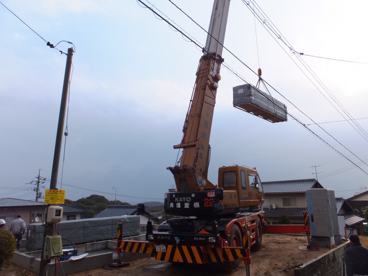 ログハウスとクレーン車